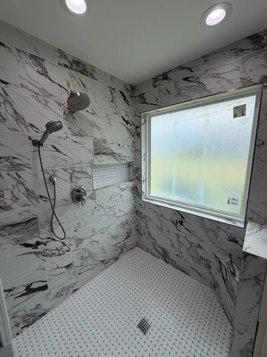 Tiled shower with wall-mounted rain head, handheld sprayer and brushed-nickel valve