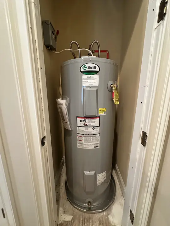 New A. O. Smith electric water heater with drain pan in a narrow hall closet