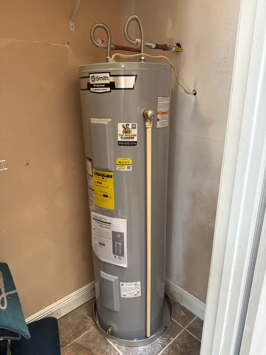 New tall A. O. Smith ProLine electric water heater with drain pan in a closet
