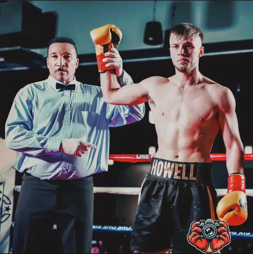 Cade Howell having his glove raised by the referee after a boxing match